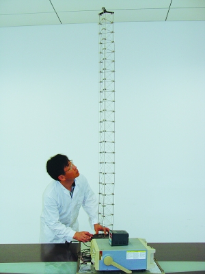 這是伸展開(kāi)的衛星太陽(yáng)能電池用盤(pán)壓伸桿，20厘米長(cháng)螺旋狀的盤(pán)壓伸桿（右側小圖）打開(kāi)后能達2米長(cháng)（8月7日攝）。（新華社發(fā)）